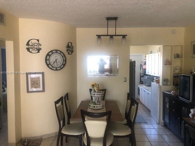 3600 SW 9th Ter Unit 1B, Miami, FL 33135 - dining room with light tile patterned floors and a textured ceiling