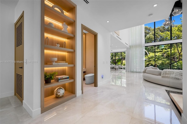1351 SW 16th St, Miami, FL 33145 - corridor featuring built in features, light marble finish flooring, and a towering ceiling