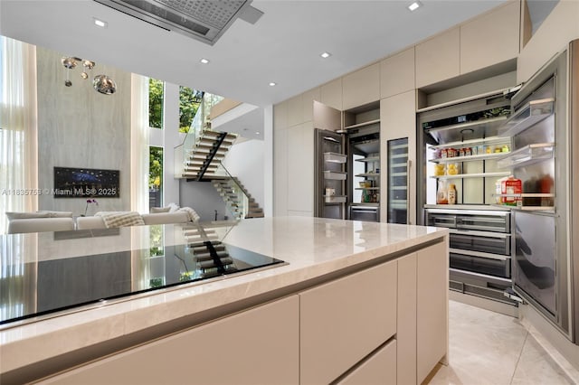 1351 SW 16th St, Miami, FL 33145 - kitchen with open floor plan, black electric stovetop, light stone counters, recessed lighting, and cream cabinetry