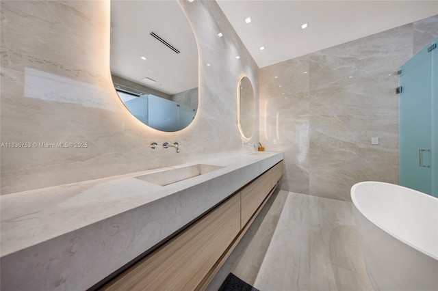 1351 SW 16th St, Miami, FL 33145 - bathroom with tile walls, double vanity, a freestanding bath, marble tiled flooring, and a shower with door