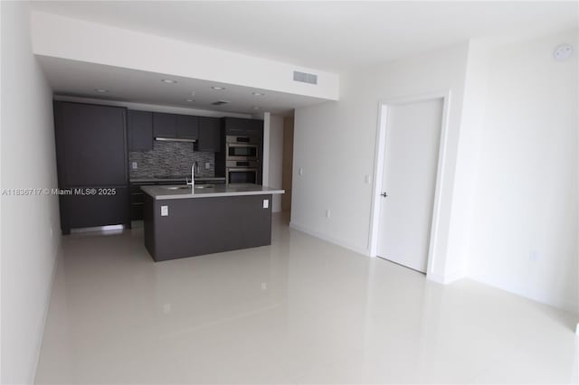 7875 NW 107th Ct Unit 519 4, Doral, FL 33178 - kitchen featuring tasteful backsplash, double oven, modern cabinets, light countertops, and a center island with sink