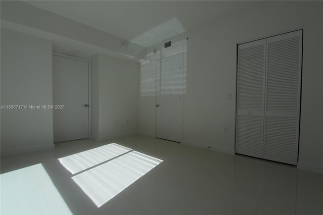 7875 NW 107th Ct Unit 519 4, Doral, FL 33178 - unfurnished bedroom with multiple closets and tile patterned floors