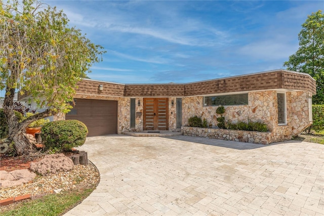 5712 White Hickory Cir, Tamarac, FL 33319 - front of property featuring mansard roof, stone siding, an attached garage, driveway, and french doors