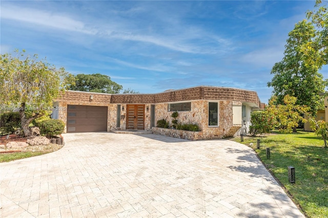 5712 White Hickory Cir, Tamarac, FL 33319 - front facade with stone siding, an attached garage, decorative driveway, a front yard, and french doors