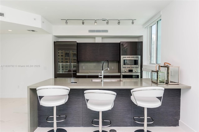 1080 Brickell Ave Unit 1708, Miami, FL 33131 - kitchen featuring appliances with stainless steel finishes, modern cabinets, a breakfast bar, and light countertops