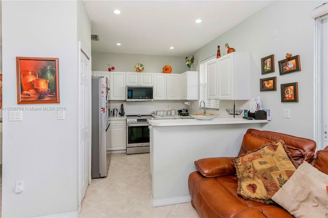 12548 SW 126th Ave, Miami, FL 33186 - kitchen featuring appliances with stainless steel finishes, a peninsula, white cabinetry, light countertops, and recessed lighting