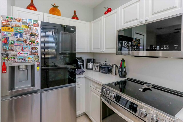 12548 SW 126th Ave, Miami, FL 33186 - kitchen with stainless steel appliances, white cabinetry, and light countertops