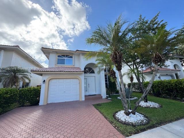 628 Turtle Run, Weston, FL 33326 - mediterranean / spanish-style home featuring stucco siding, a garage, decorative driveway, and a tile roof
