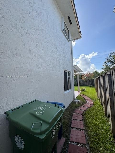 628 Turtle Run, Weston, FL 33326 - view of side of home featuring stucco siding and a fenced backyard