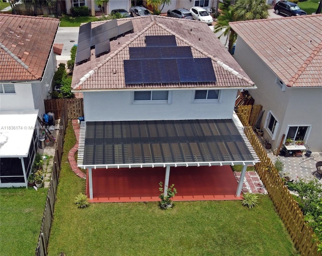 628 Turtle Run, Weston, FL 33326 - back of house with stucco siding, roof mounted solar panels, a fenced backyard, and a tiled roof
