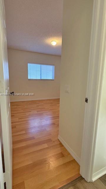628 Turtle Run, Weston, FL 33326 - spare room featuring light wood-type flooring and a textured ceiling