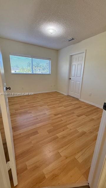 628 Turtle Run, Weston, FL 33326 - spare room with light wood-style floors and a textured ceiling
