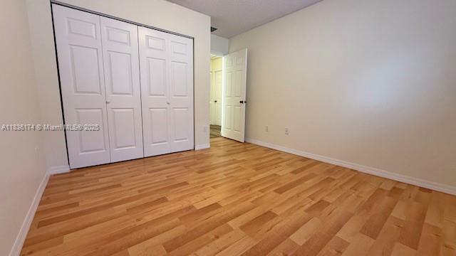 628 Turtle Run, Weston, FL 33326 - unfurnished bedroom featuring light wood finished floors and a closet