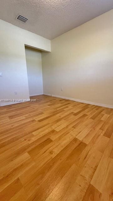 628 Turtle Run, Weston, FL 33326 - empty room with light wood-type flooring and a textured ceiling