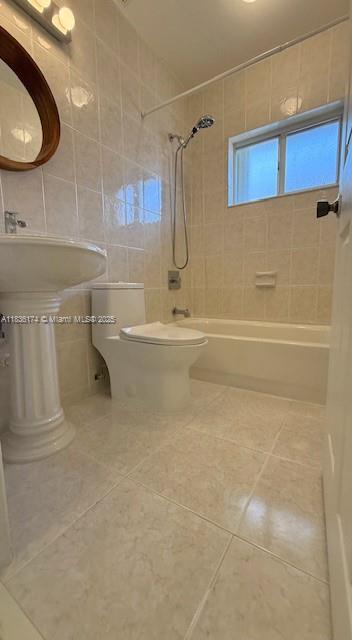 628 Turtle Run, Weston, FL 33326 - bathroom featuring tile walls, tile patterned flooring, and bathing tub / shower combination