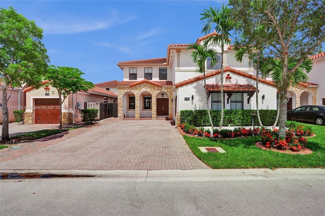 1007 NW 99th Ct, Miami, FL 33172 - mediterranean / spanish-style home featuring stucco siding, decorative driveway, a tiled roof, and stone siding