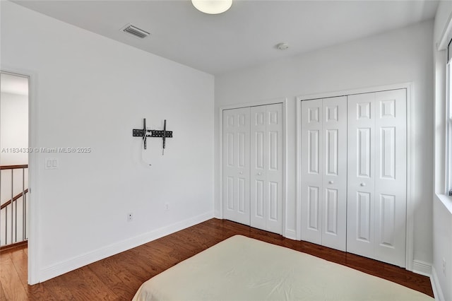 1007 NW 99th Ct, Miami, FL 33172 - unfurnished bedroom featuring two closets and dark wood-style flooring