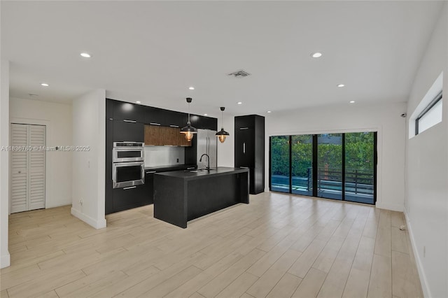 120 NW 41st St, Miami, FL 33127 - kitchen with stainless steel double oven, modern cabinets, dark countertops, pendant lighting, and light wood finished floors