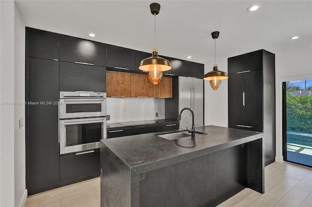 120 NW 41st St, Miami, FL 33127 - kitchen with dark cabinets, dark countertops, double oven, hanging light fixtures, and modern cabinets