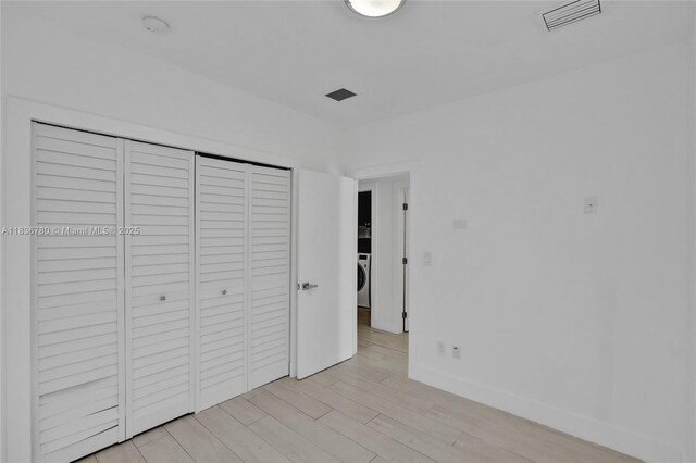 120 NW 41st St, Miami, FL 33127 - unfurnished bedroom featuring light wood finished floors, a closet, and washer / clothes dryer