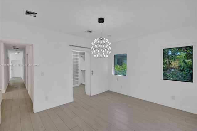 120 NW 41st St, Miami, FL 33127 - unfurnished room with plenty of natural light, a chandelier, and light wood-style flooring