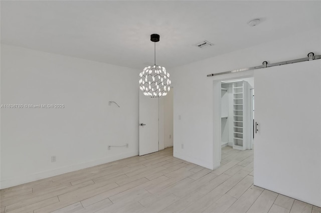 120 NW 41st St, Miami, FL 33127 - spare room with a barn door, light wood-type flooring, a chandelier, and stairway
