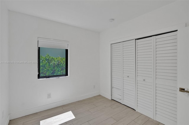 120 NW 41st St, Miami, FL 33127 - unfurnished bedroom with light wood-style flooring and a closet