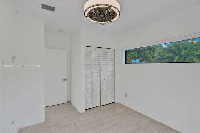 120 NW 41st St, Miami, FL 33127 - unfurnished bedroom featuring light wood-style flooring and a closet