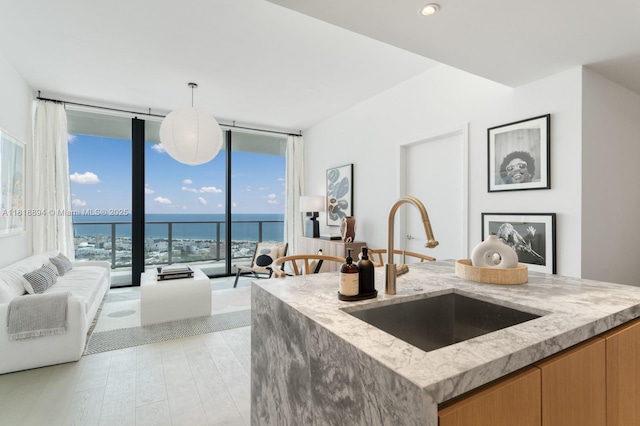 500 Alton Rd Unit 4004, Miami Beach, FL 33139 - kitchen featuring light stone counters, a wall of windows, open floor plan, decorative light fixtures, and a water view