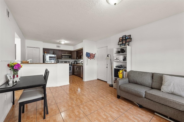 3660 N 56th Ave Unit 602, Hollywood, FL 33021 - living room featuring light tile patterned floors and a textured ceiling