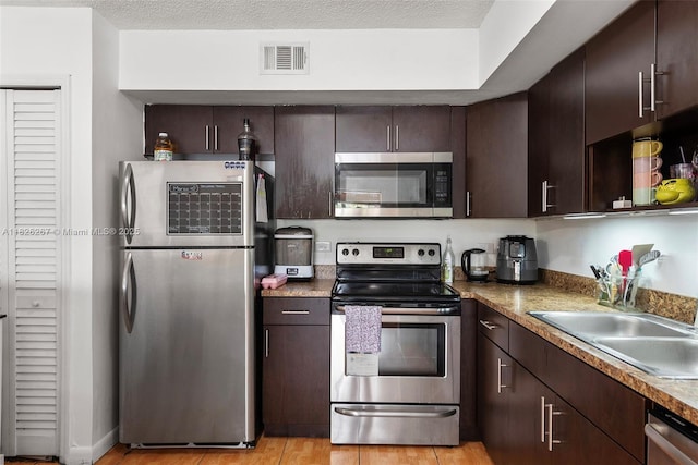 3660 N 56th Ave Unit 602, Hollywood, FL 33021 - kitchen featuring appliances with stainless steel finishes, dark brown cabinets, and light wood-style floors