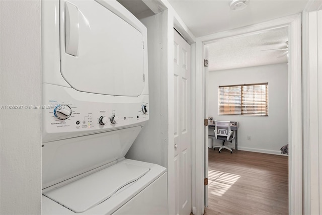 3660 N 56th Ave Unit 602, Hollywood, FL 33021 - laundry room with stacked washer and clothes dryer, light wood-style flooring, a textured ceiling, and a desk