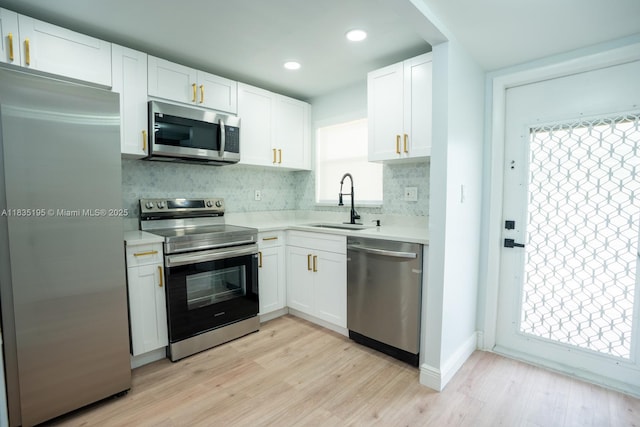 2780 N Pine Island Rd Unit 211, Sunrise, FL 33322 - kitchen with appliances with stainless steel finishes, light countertops, backsplash, white cabinetry, and light wood-style floors
