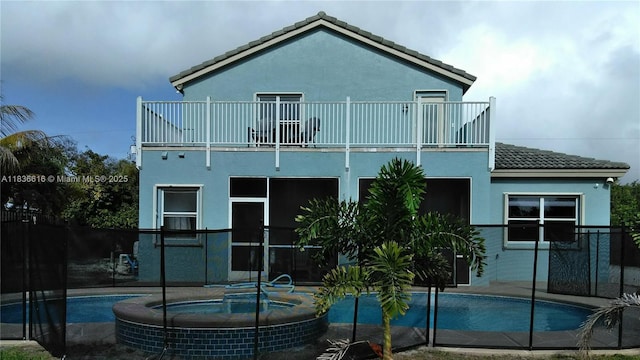 170 NE Dominican Ter, Port St Lucie, FL 34983 - back of house featuring a balcony, a tile roof, and stucco siding