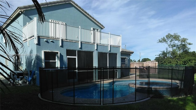 170 NE Dominican Ter, Port St Lucie, FL 34983 - rear view of house featuring a balcony, stucco siding, a pool with connected hot tub, and a tile roof