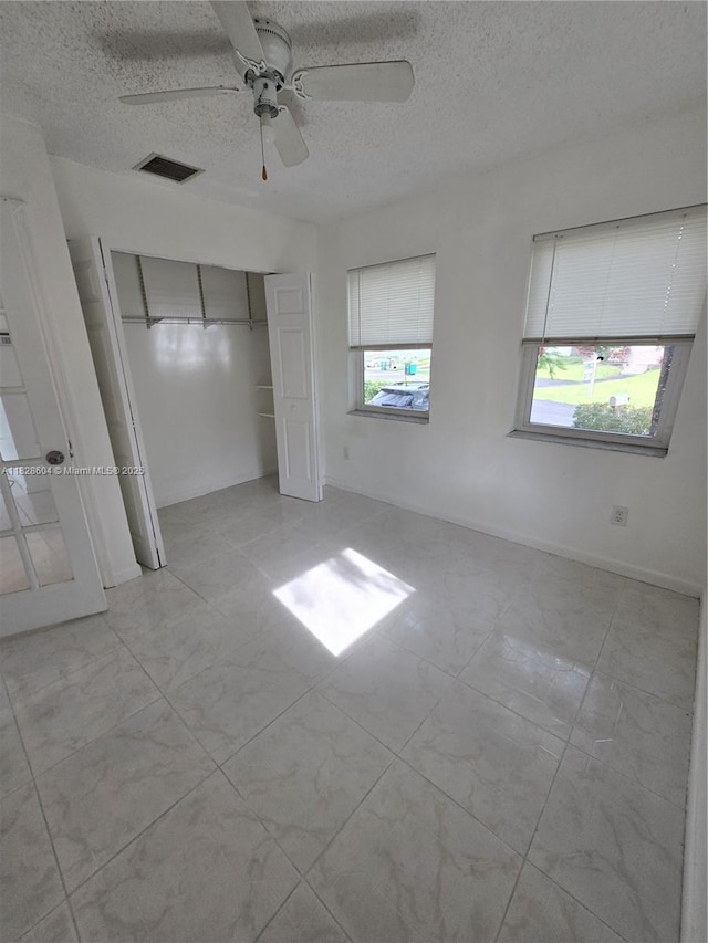 13567 SW 286th Ter, Homestead, FL 33033 - unfurnished bedroom with a textured ceiling, a closet, and a ceiling fan