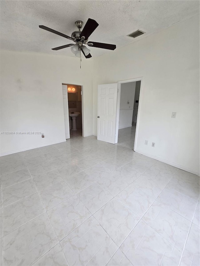 13567 SW 286th Ter, Homestead, FL 33033 - unfurnished bedroom featuring a textured ceiling, connected bathroom, and ceiling fan