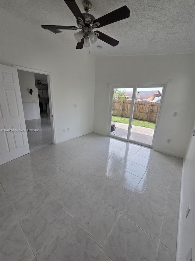 13567 SW 286th Ter, Homestead, FL 33033 - empty room with a ceiling fan, a textured ceiling, and marble look tiles