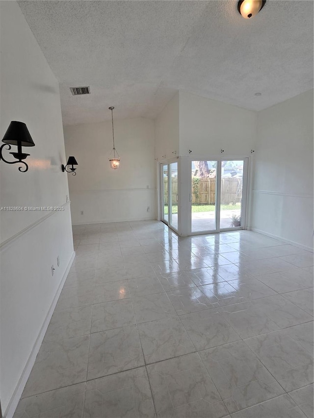 13567 SW 286th Ter, Homestead, FL 33033 - spare room featuring a textured ceiling and a towering ceiling