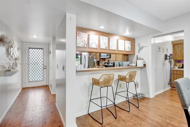 1532 Whitehall Dr Unit 202, Davie, FL 33324 - kitchen with wood finished floors, a breakfast bar, stainless steel appliances, and recessed lighting