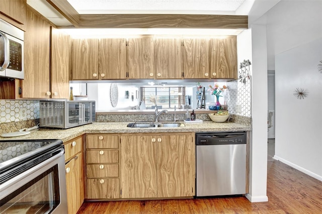 1532 Whitehall Dr Unit 202, Davie, FL 33324 - kitchen with appliances with stainless steel finishes, light countertops, light wood finished floors, and backsplash