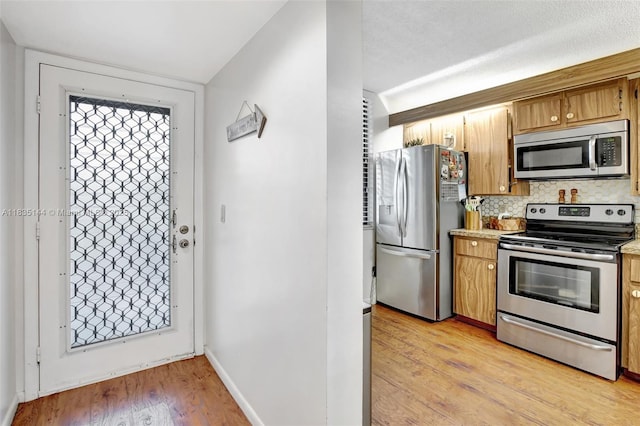1532 Whitehall Dr Unit 202, Davie, FL 33324 - kitchen featuring stainless steel appliances, decorative backsplash, light wood finished floors, light countertops, and brown cabinets