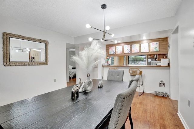 1532 Whitehall Dr Unit 202, Davie, FL 33324 - dining space with a chandelier, wood finished floors, and a textured ceiling
