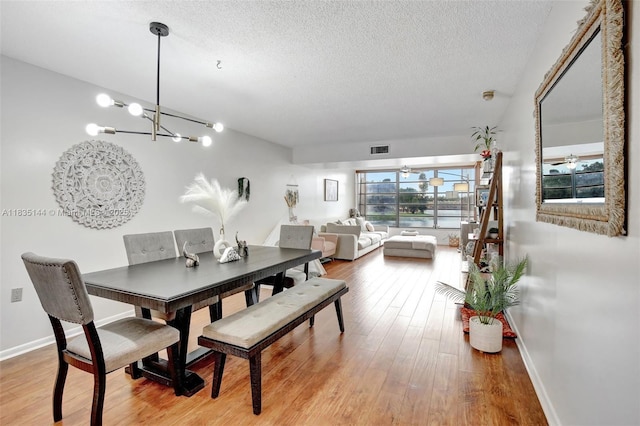 1532 Whitehall Dr Unit 202, Davie, FL 33324 - dining space featuring a chandelier, a textured ceiling, and wood finished floors