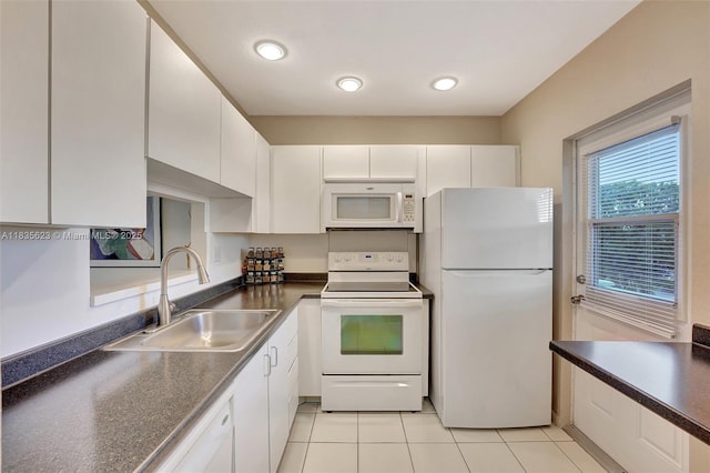 4805 NW 35th St Unit 603, Lauderdale Lakes, FL 33319 - kitchen with white appliances, dark countertops, white cabinetry, and light tile patterned floors