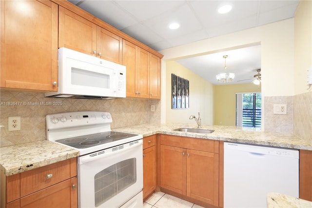 10332 Sunrise Lakes Blvd Unit 206, Sunrise, FL 33322 - kitchen featuring white appliances, a peninsula, a chandelier, backsplash, and light stone counters