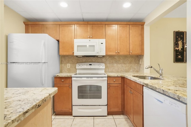 10332 Sunrise Lakes Blvd Unit 206, Sunrise, FL 33322 - kitchen featuring white appliances, light stone counters, light tile patterned flooring, decorative backsplash, and brown cabinets
