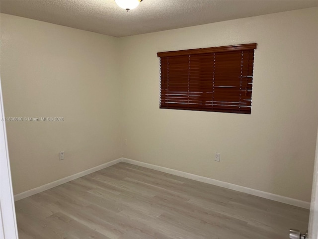 6060 W 21st Ct Unit 205, Hialeah, FL 33016 - empty room featuring light wood-type flooring and a textured ceiling