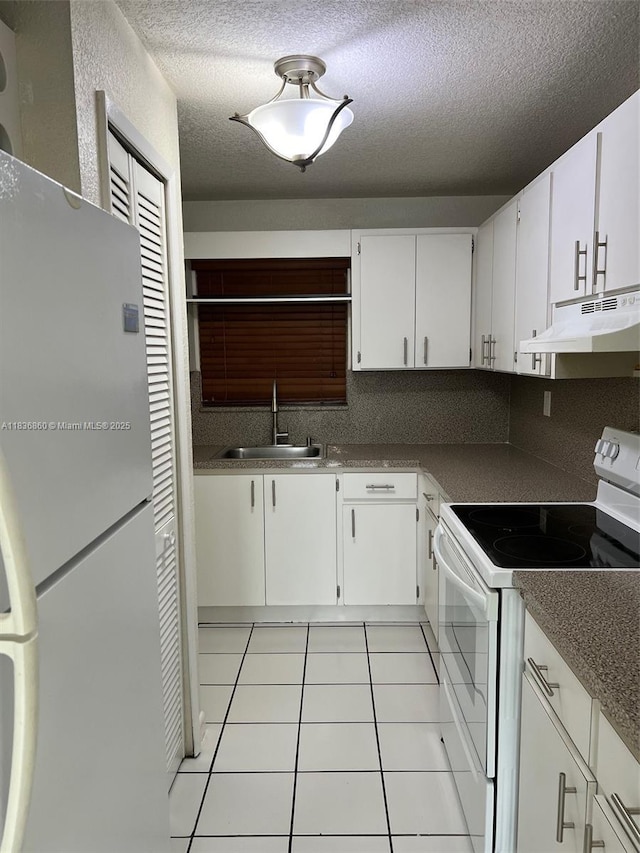 6060 W 21st Ct Unit 205, Hialeah, FL 33016 - kitchen featuring white appliances, under cabinet range hood, light tile patterned floors, a textured ceiling, and white cabinetry