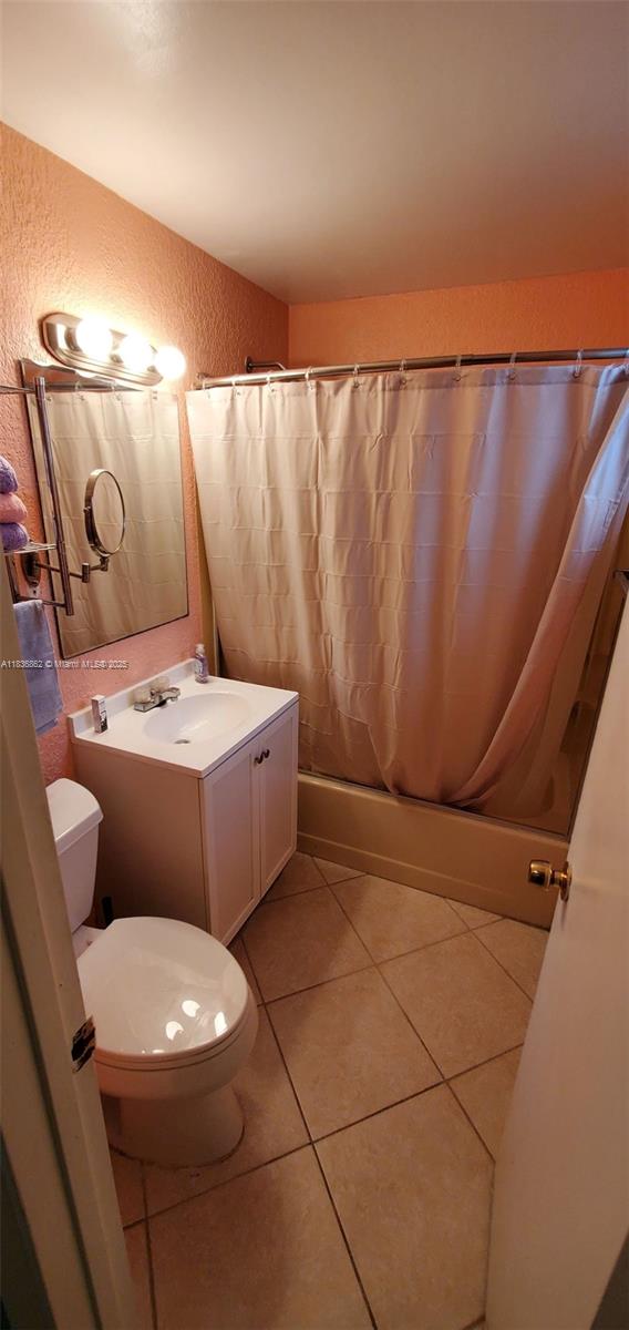 1679 NE 175th St, North Miami Beach, FL 33162 - full bath with a textured wall, shower / tub combo, vanity, and tile patterned floors